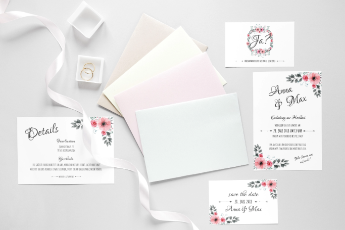 Einladungen und Karten in sanften Farben mit floralem Design und einem eleganten Band.